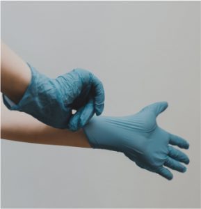 A person wearing blue gloves and blue latex gloves, ready for work.